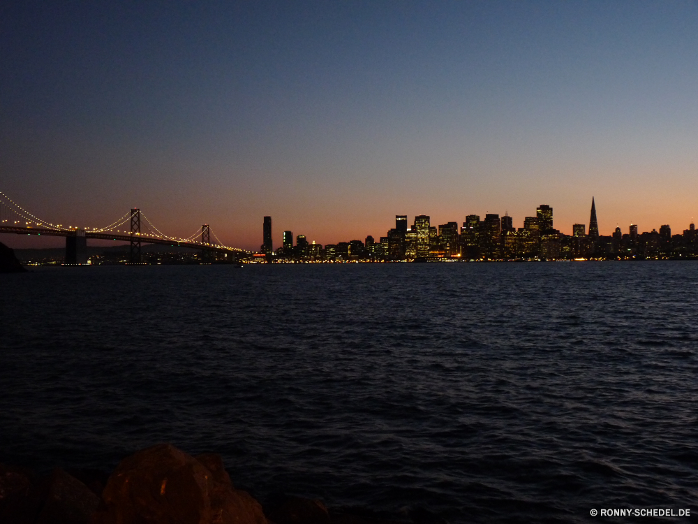 Skyline von San Francisco am Abend am Wasser Anlegestelle Stadt Nacht Schiff Fluss Wasser Architektur Reisen Unterstützung Himmel Stadtansicht Brücke Gebäude Ozean Gerät Tourismus Wahrzeichen Schiff Urban Meer Turm Reflexion Skyline Boot Öltanker Sonnenuntergang Tourist Frachtschiff Lichter Insel Innenstadt Gebäude Stadt Landschaft Licht alt Küstenlinie See berühmte Kirche 'Nabend Straße dunkel Hafen Wolkenkratzer Panorama Bucht Szene Versand Urlaub Hafen Hauptstadt Sommer Handwerk historischen Struktur Küste Dämmerung Wolke Zentrum Wolken Haus Palast moderne Straße Horizont Geschichte landschaftlich Marina Pazifik Bau beleuchtete Körper des Wassers Ziel Kontur Sonne Neu Büro waterfront pier city night ship river water architecture travel support sky cityscape bridge building ocean device tourism landmark vessel urban sea tower reflection skyline boat oil tanker sunset tourist cargo ship lights island downtown buildings town landscape light old shoreline lake famous church evening street dark port skyscraper panorama bay scene shipping vacation harbor capital summer craft historic structure coast dusk cloud center clouds house palace modern road horizon history scenic marina pacific construction illuminated body of water destination silhouette sun new office